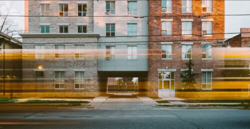 photo of school building with a school bus driving by